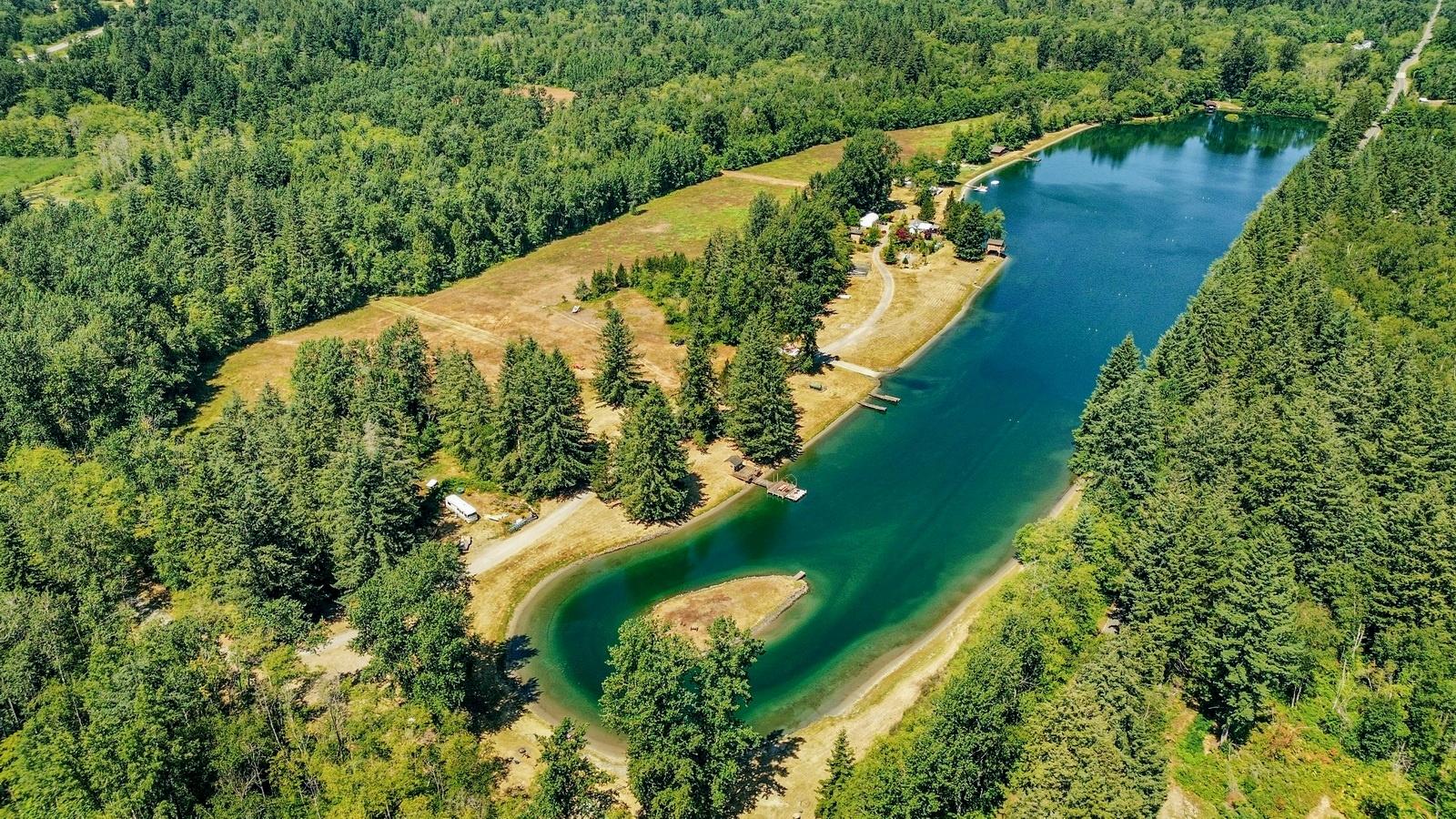 Aerial view of 8610 White Road, showing the lake and surrounding forested land